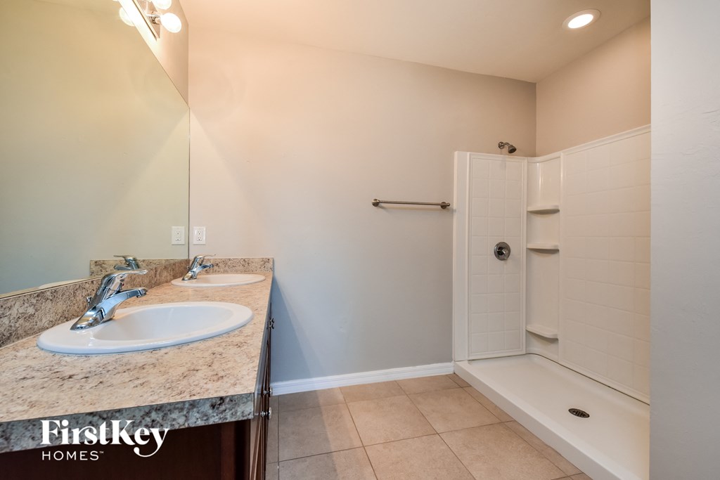 a bathroom with two sinks and a tub and a shower