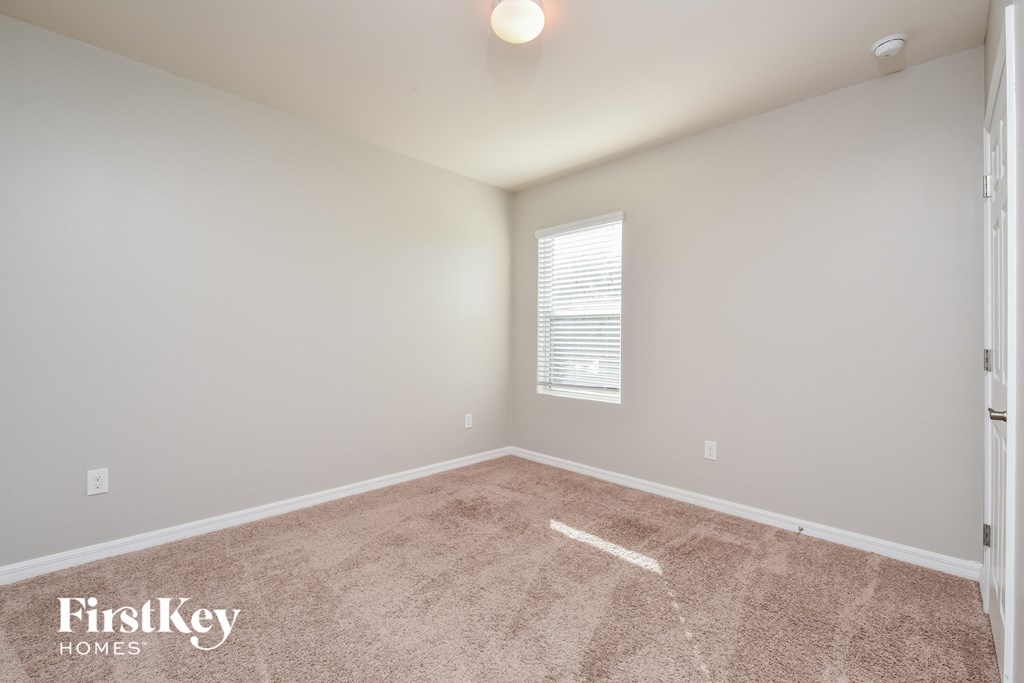 a spacious room with carpet and a window