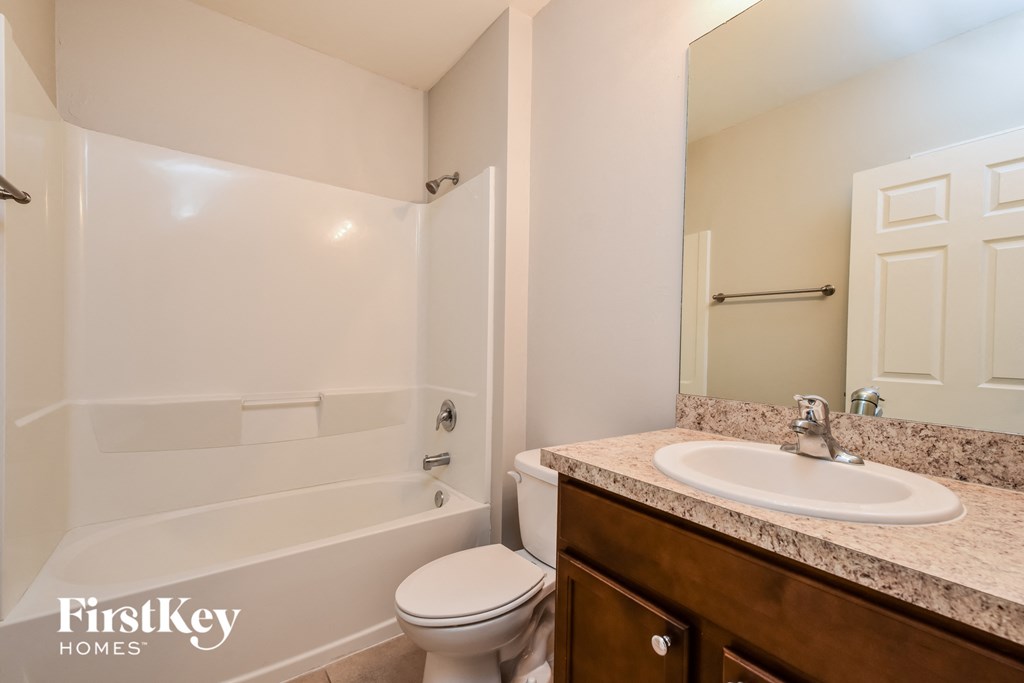 a bathroom with a shower toilet and sink and a mirror