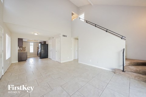 A spacious living room with a staircase on the right side.