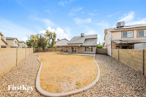 A backyard with a gravel path and a few trees.