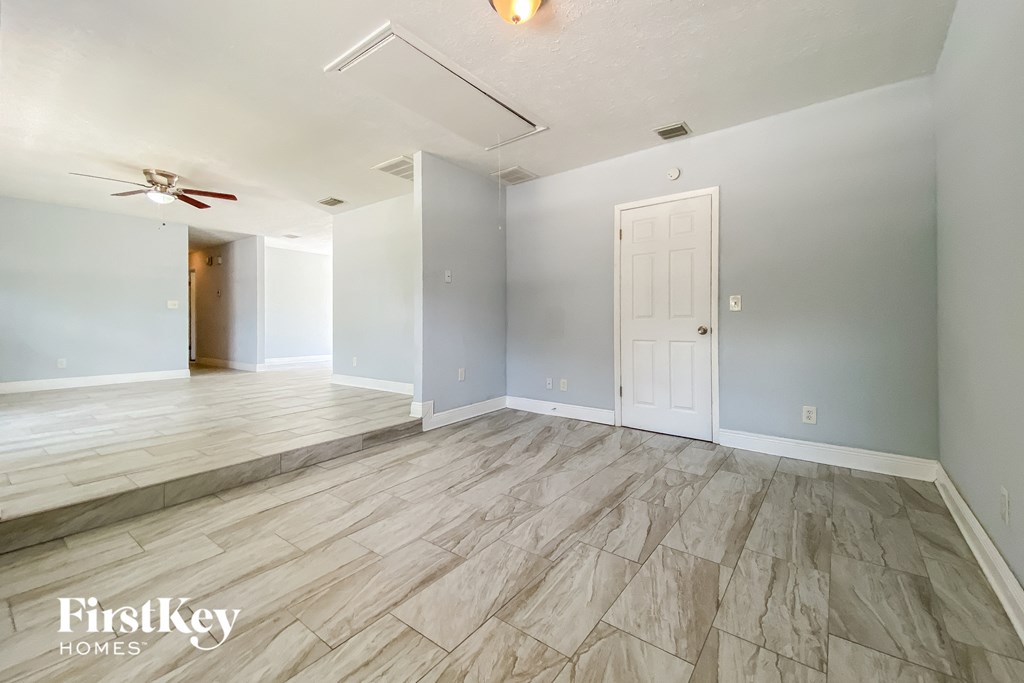 A room with a wooden floor and a ceiling fan.