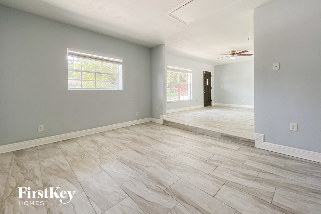A spacious room with light grey walls and a wooden floor.