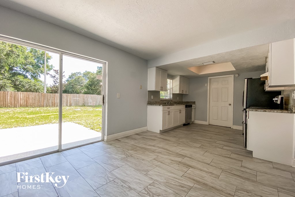 A kitchen with a sliding glass door leading to a backyard.