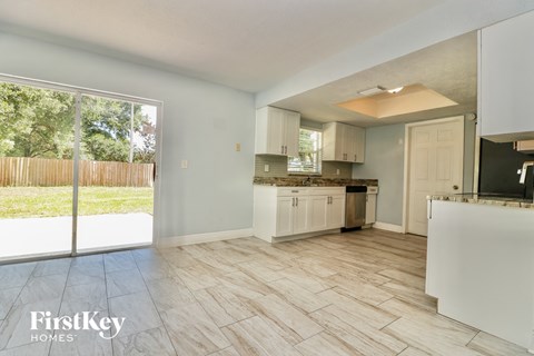 A kitchen with a white counter top and cabinets.