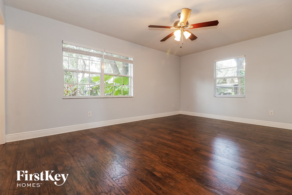 A room with wooden floors and a ceiling fan.