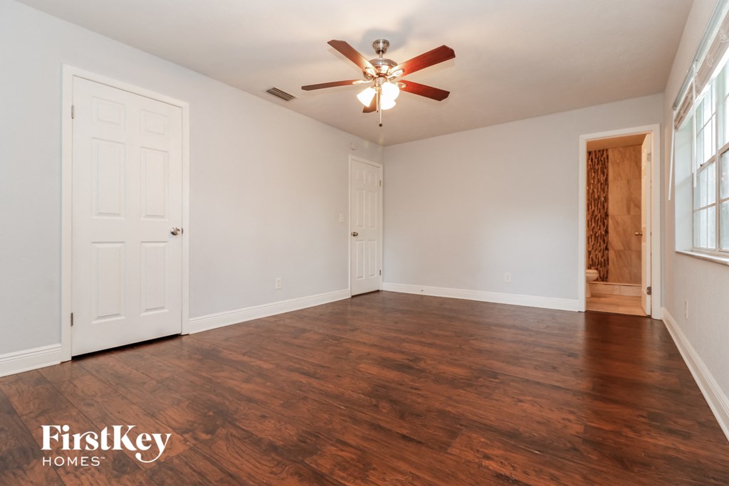 A room with wooden floors and a ceiling fan.