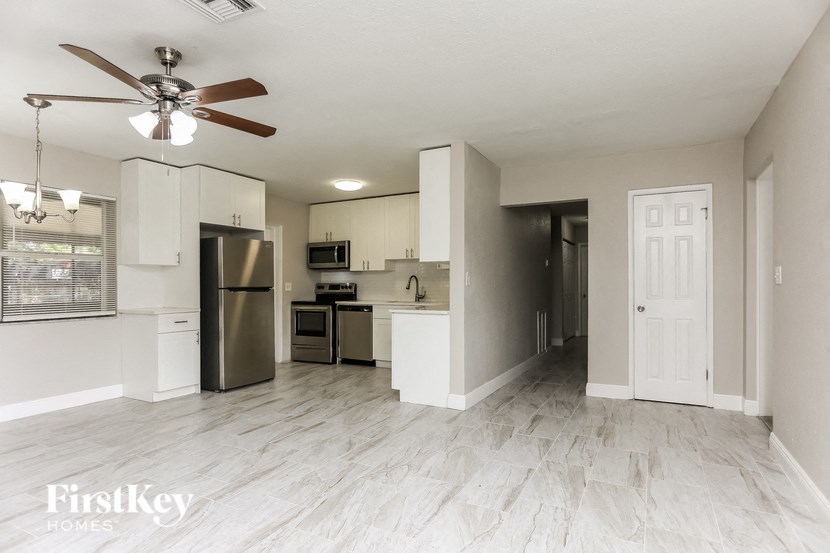 A spacious kitchen with a refrigerator, microwave, oven, and sink.
