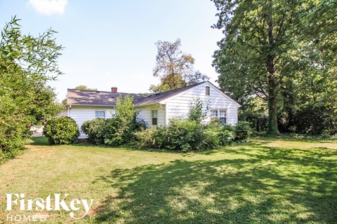 a white house with a yard and trees