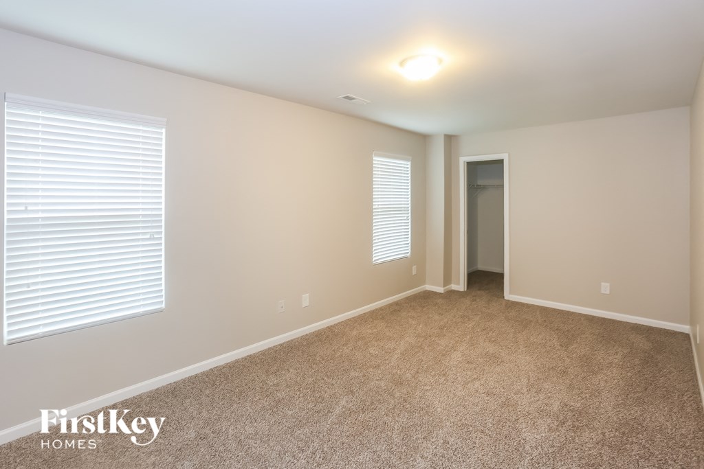 A room with a carpeted floor and a doorway leading to another room.