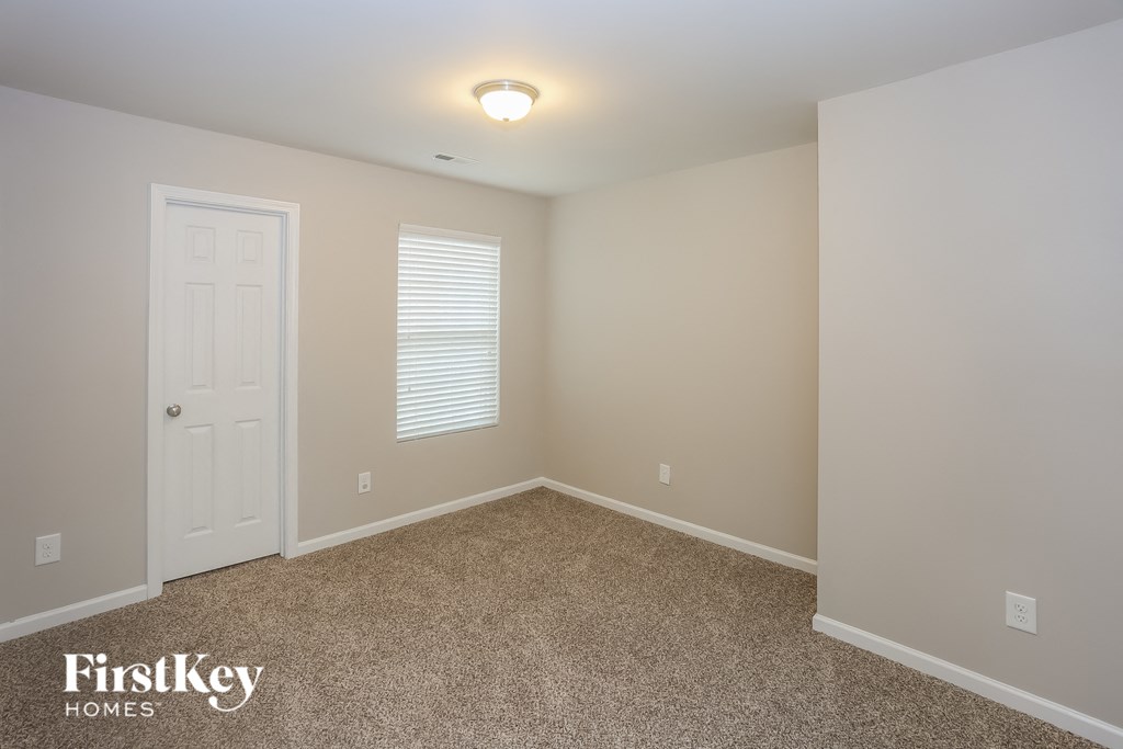A room with a carpeted floor and a door.