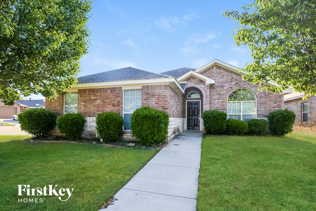a brick house with a sidewalk in front of it