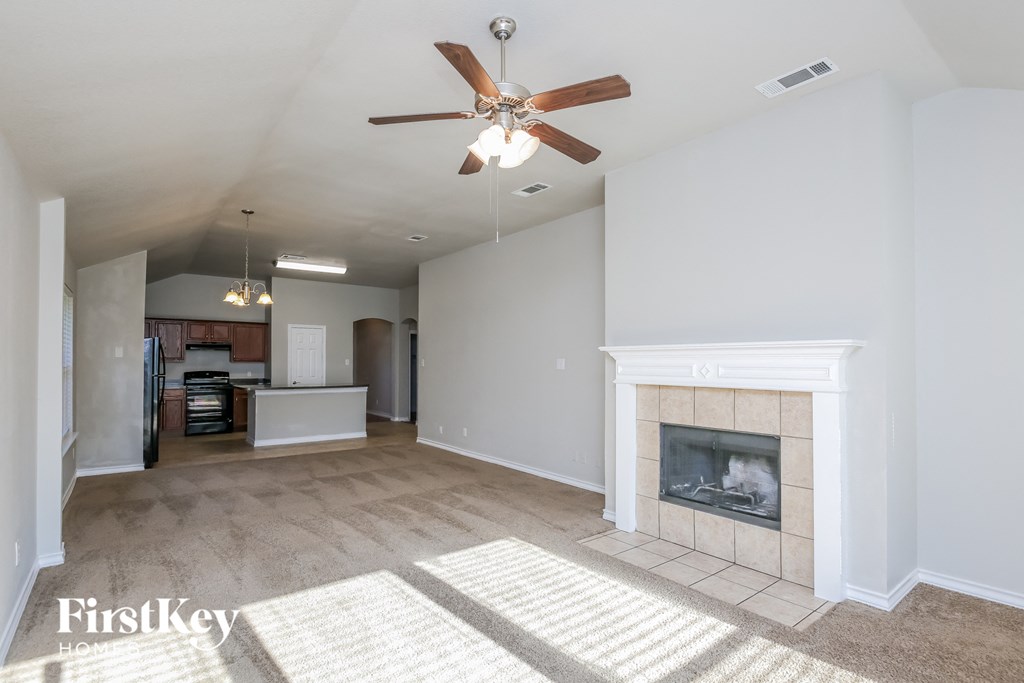 a living room with a fireplace and a ceiling fan