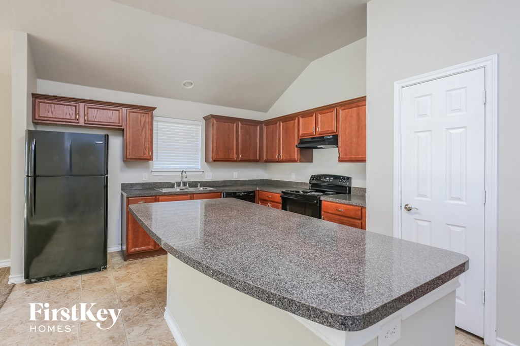 a kitchen with granite counter tops and wooden cabinets