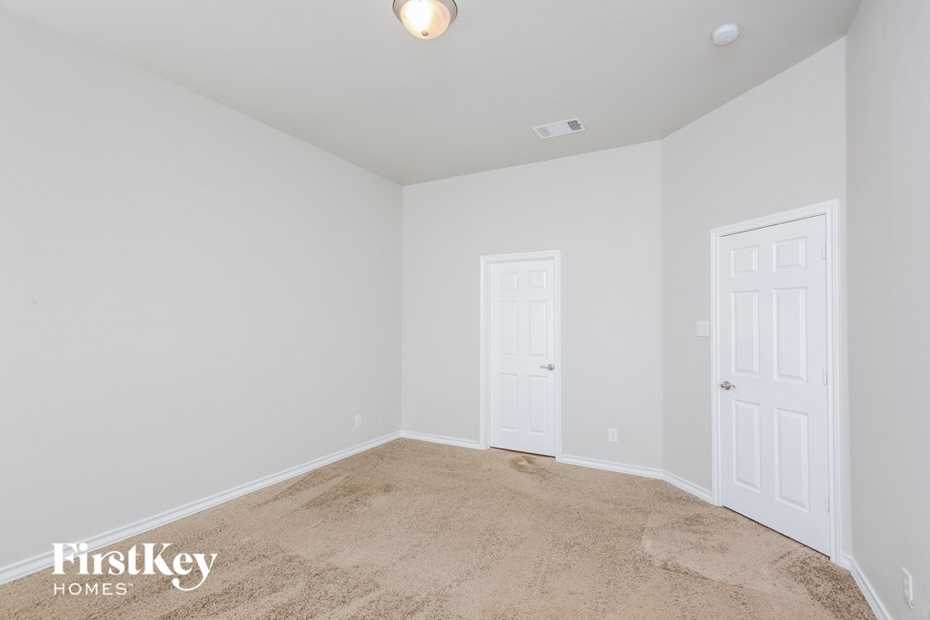 a bedroom with a carpeted floor and a white door