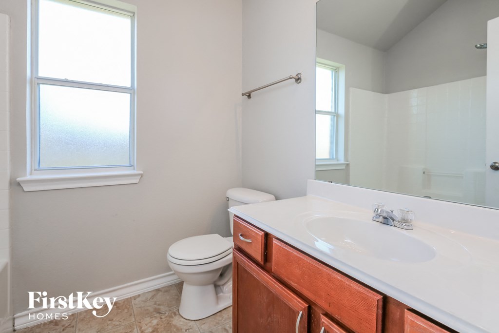 a bathroom with a toilet and a sink and a mirror