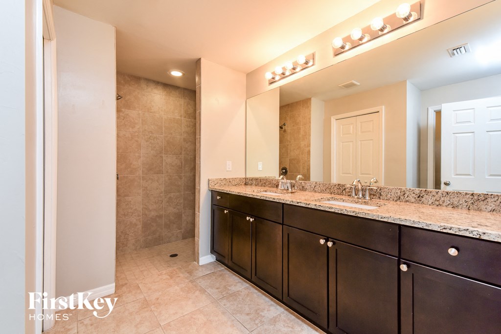 a master bathroom with a large vanity and a large mirror