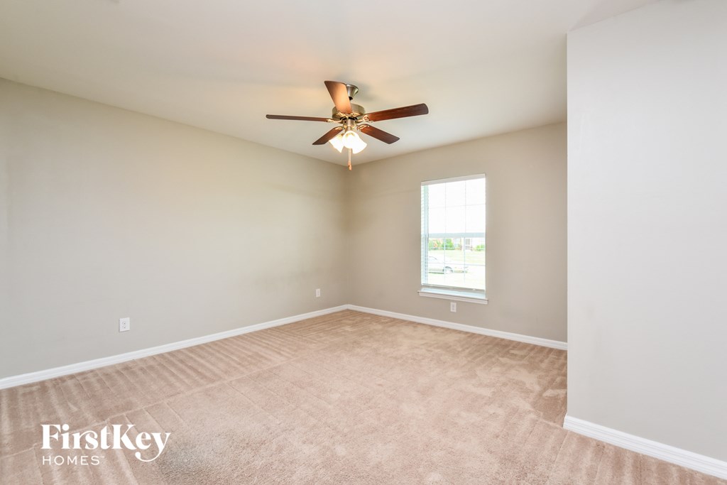 an empty room with a ceiling fan and a window