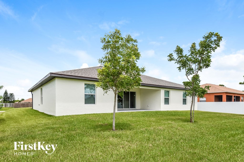 a white house with two trees in the yard