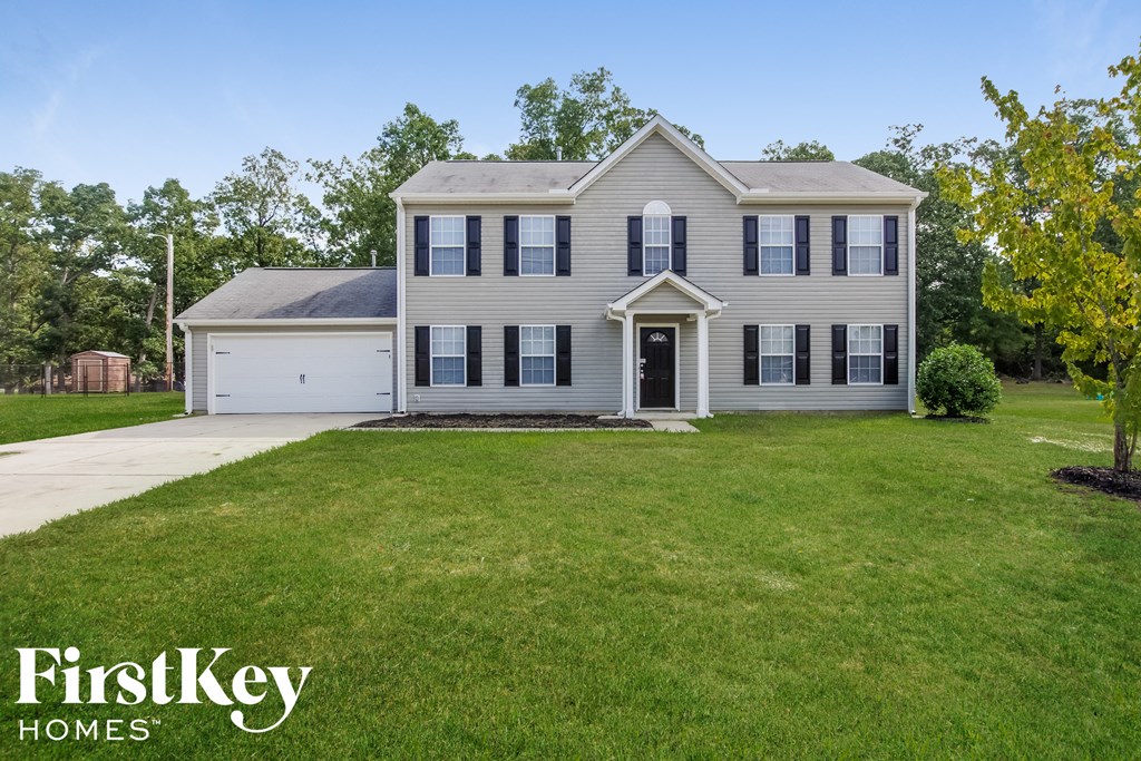 a white house with black shutters and a lawn