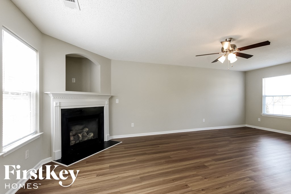 a living room with a fireplace and a ceiling fan