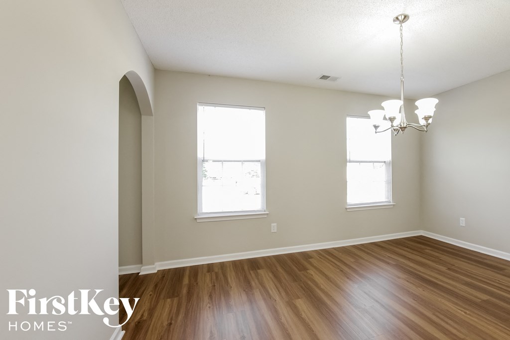 a living room with a hard wood floor and two windows