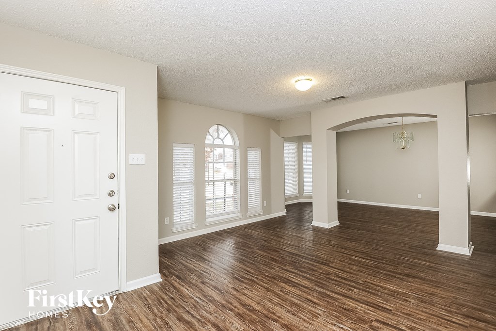 the living room and dining room of an empty house with wood flooring