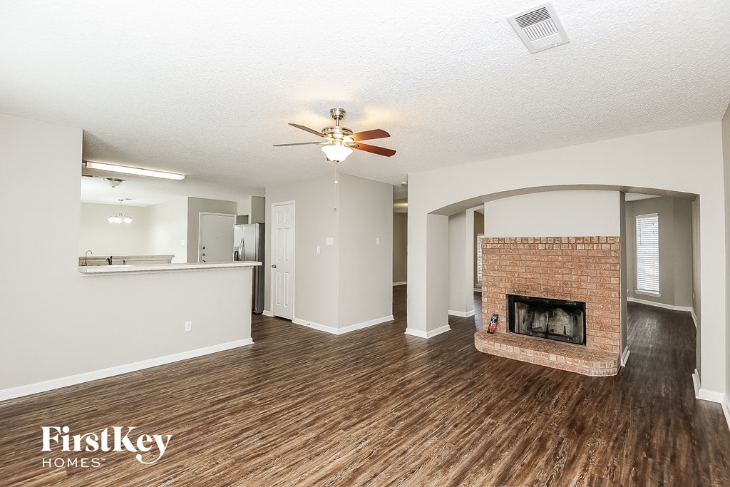 a living room with a fireplace and a ceiling fan