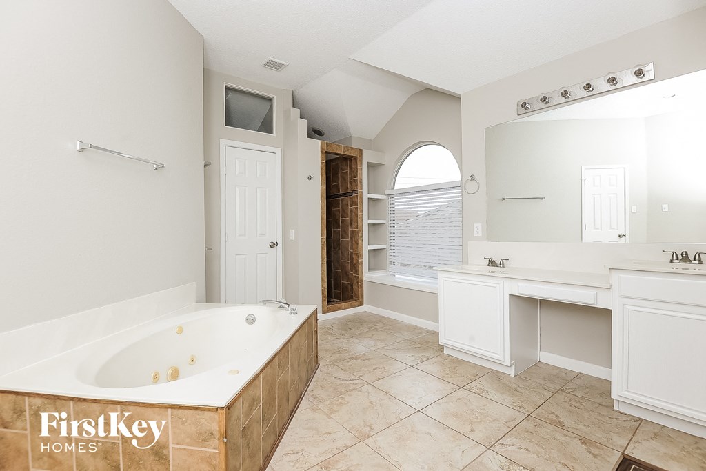 a large white bathroom with a large tub and a sink