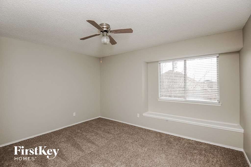 a bedroom with a ceiling fan and a window