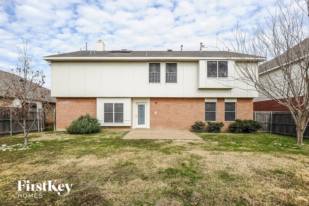 a white and brick house with a yard in front of it