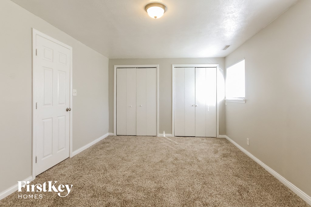 a bedroom with two closets and a carpeted floor