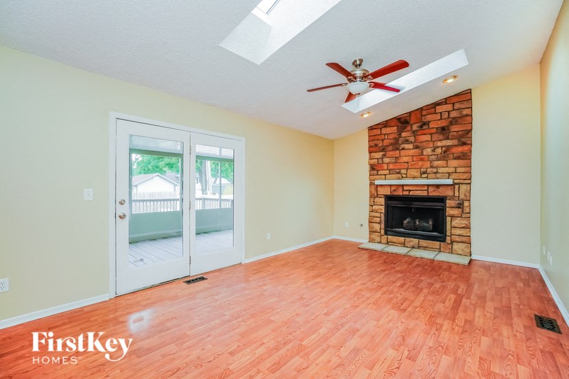 A room with a fireplace and a ceiling fan.