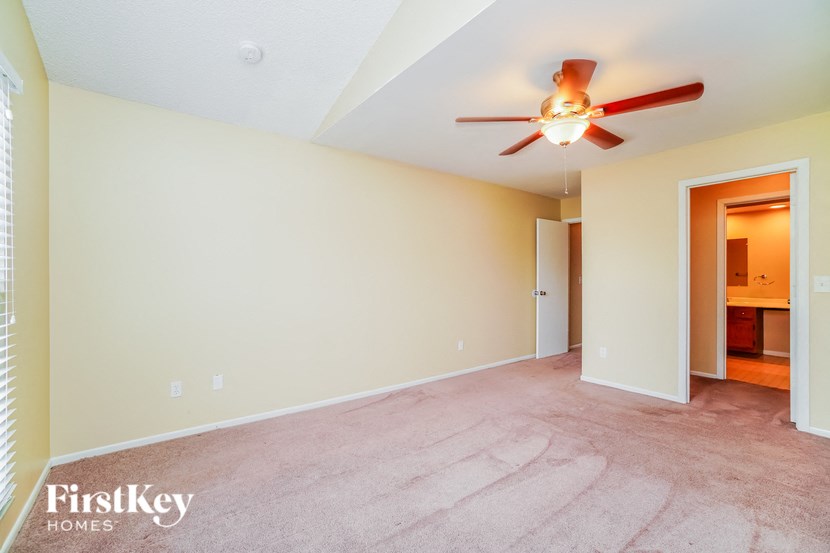 A room with a ceiling fan and a carpeted floor.