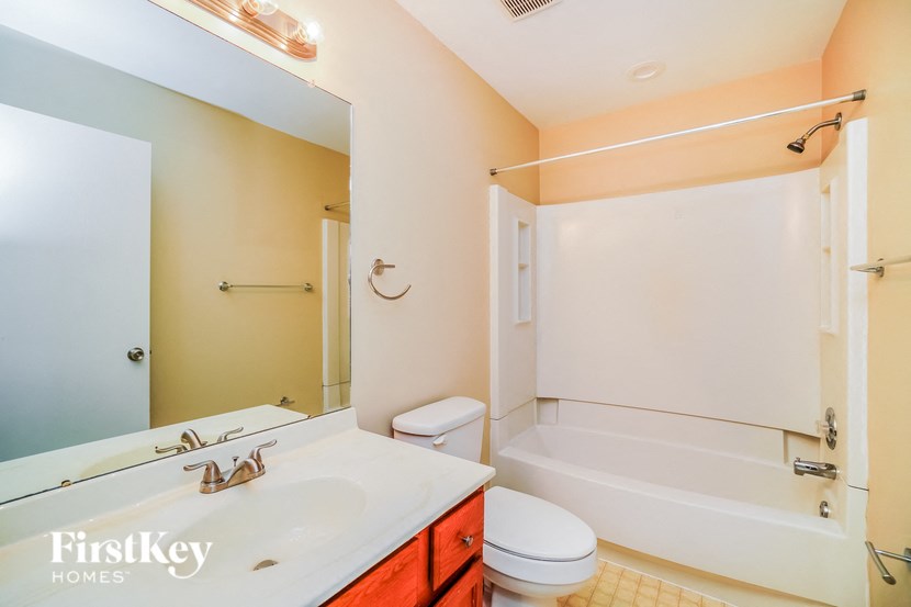 A bathroom with a white tub, toilet, and sink.
