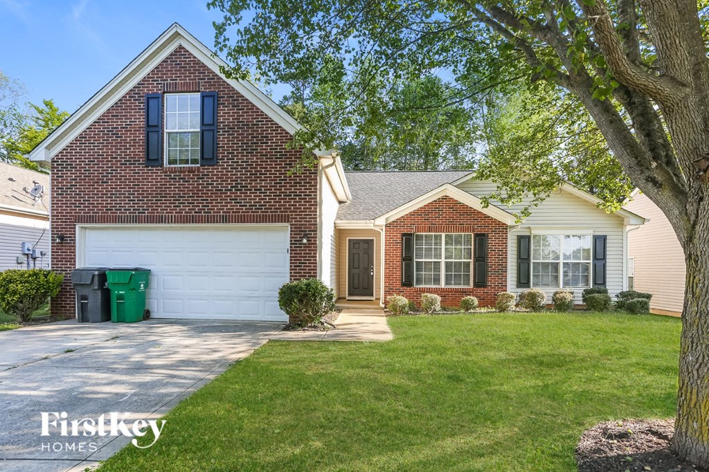 a home with a white garage door and a lawn