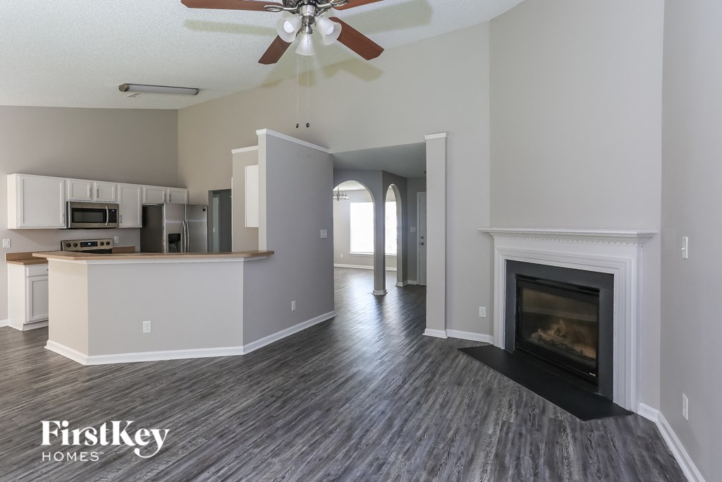a living room with a fireplace and a kitchen