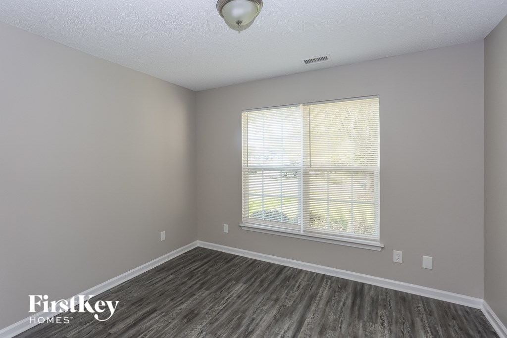 the living room of an apartment with wood floors and a large window