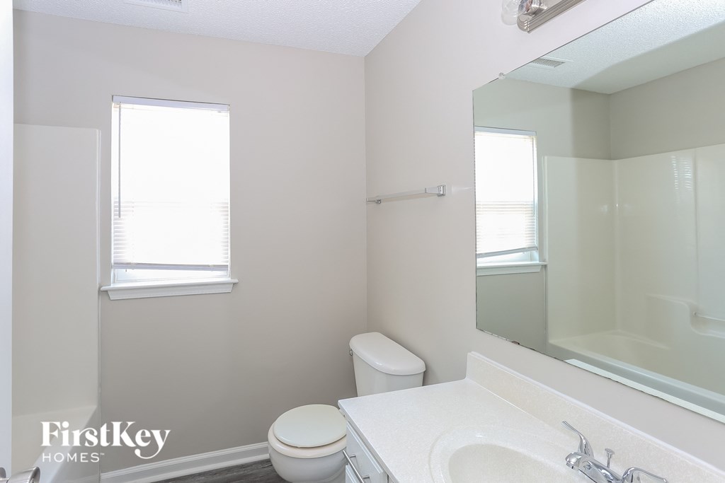 a bathroom with a sink toilet and a mirror