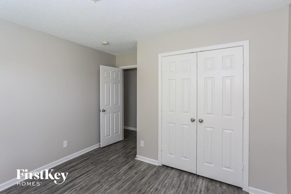 a bedroom with two closets and a door to a hallway