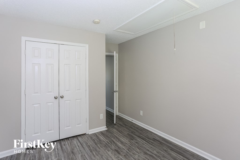 the living room of an apartment with a door to the closet