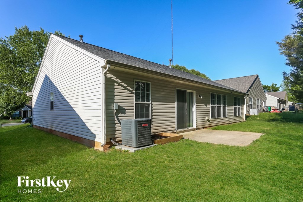 the front of a white house with a yard and a porch