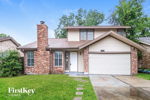A house with a garage door and a brick chimney.