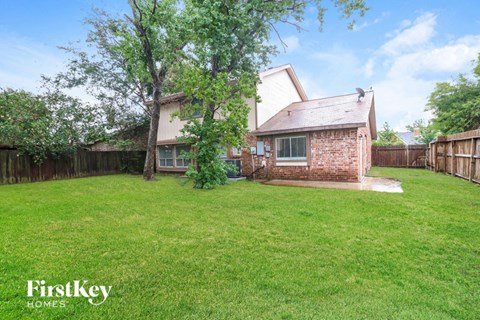 A house with a lawn and trees in the background.