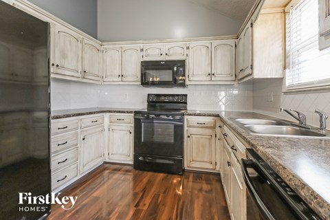 A kitchen with wooden cabinets and a black stove top oven.