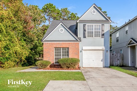 a brick house with a white garage door and a blue house