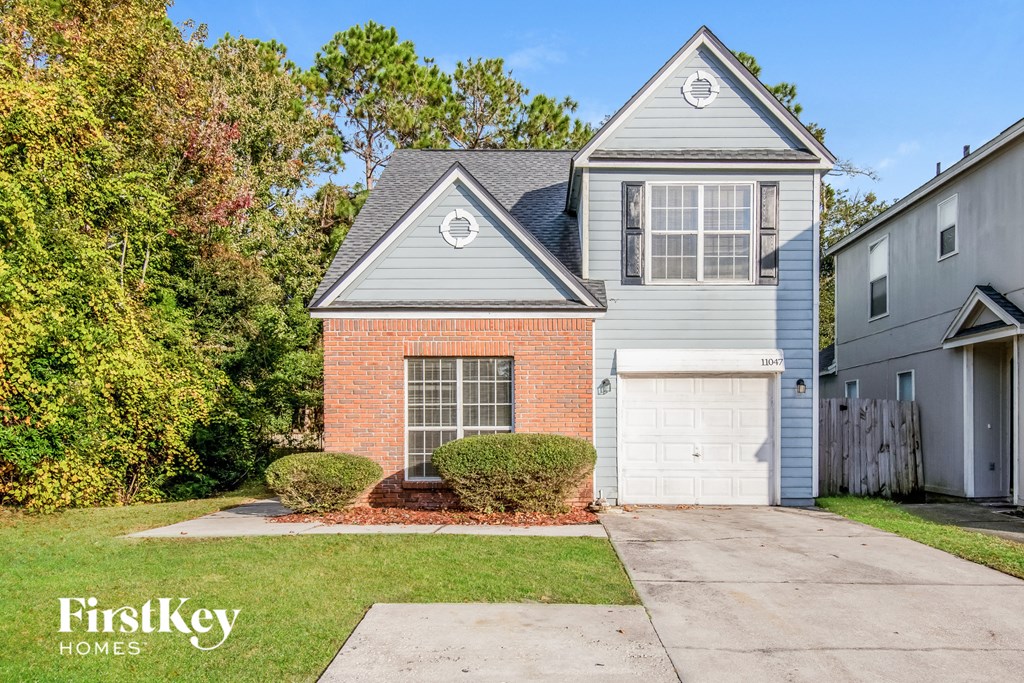 a brick house with a white garage door and a blue house
