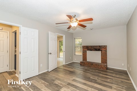 a living room with a fireplace and a ceiling fan