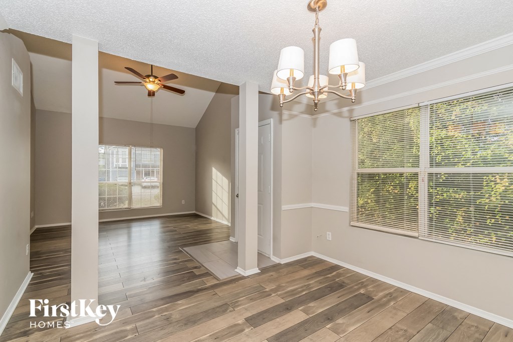 the living room and dining room with a large window and a ceiling fan