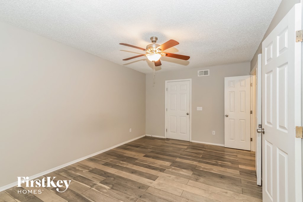 a bedroom with a ceiling fan and a white door